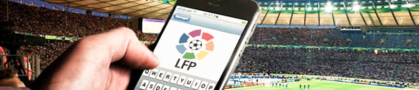 Un jugador hace una apuesta con un móvil durante un partido de fútbol